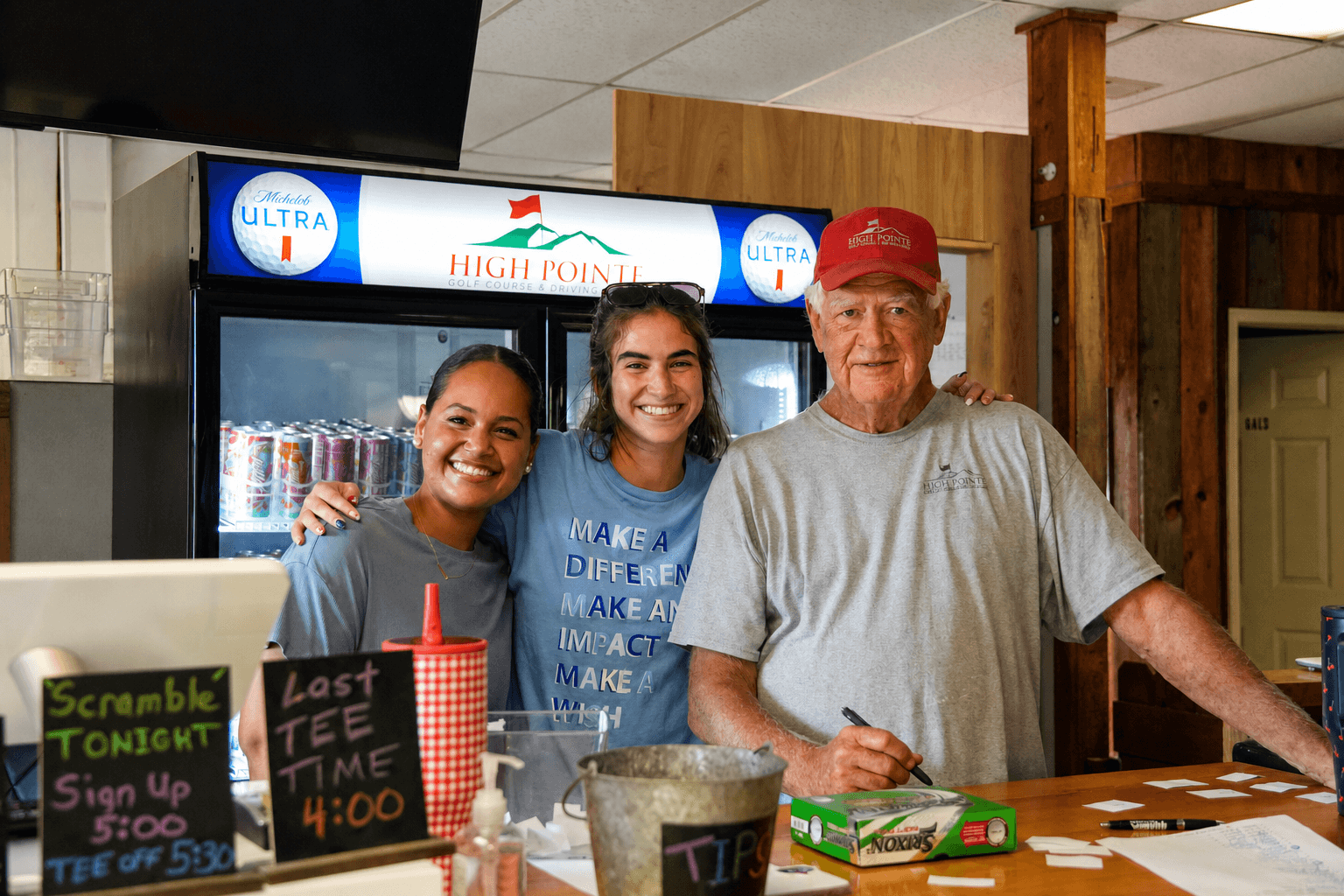 Three High Pointe staff and community members smiling together inside the clubhouse.