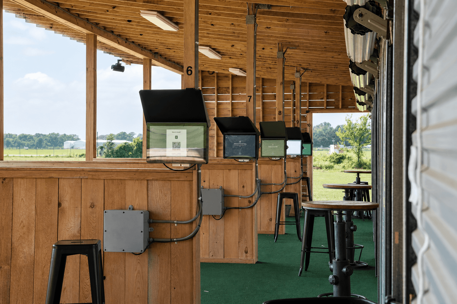 Row of Toptracer bays inside The Hangar at High Pointe Golf